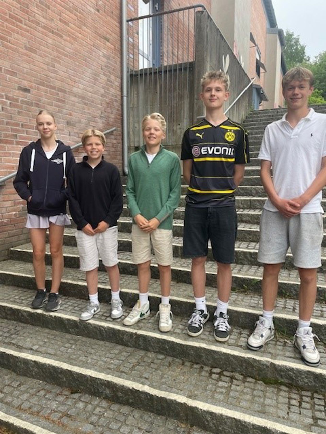 En gruppe mennesker som poserer for et bilde på en steintrapp